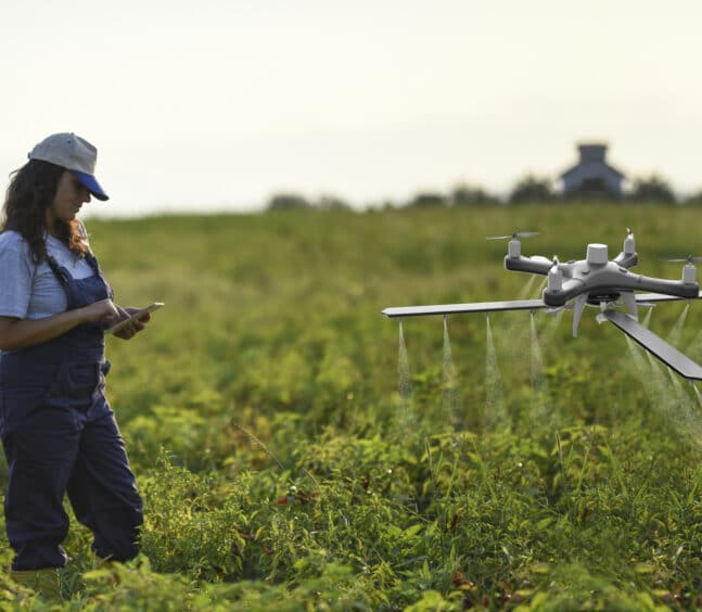 Female farmer using a drone to spray her crops