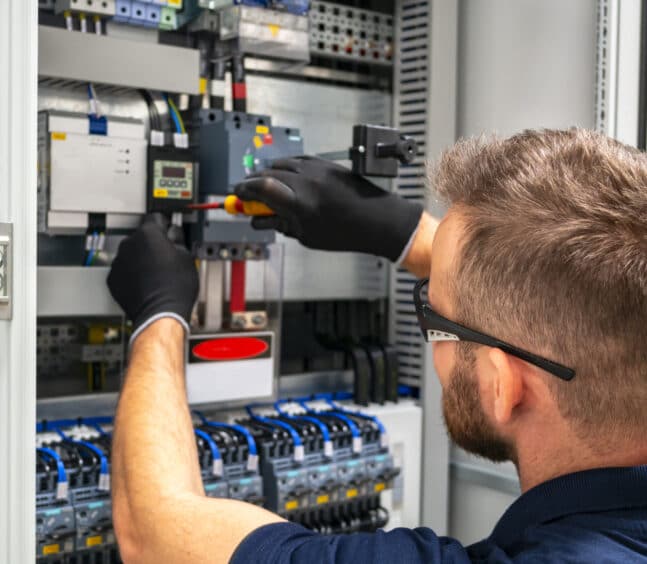 Electrician working at electric panel